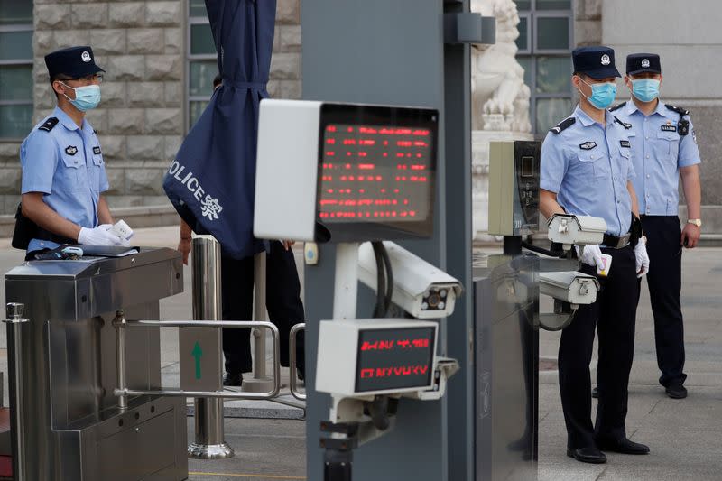 Police officers stand guard at an entrance to Beijing No. 2 Intermediate People's Court