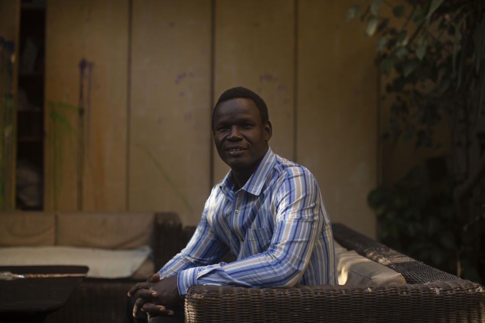 In this Nov. 27, 2019 photo, Patrice Gaudensio, a refugee artist from South Sudan poses for a portrait during an exhibition titled "Beyond Borders," featuring work by refugee artists, at Art Cafe in Cairo, Egypt. Gaudensio said he and his wife have experienced racism and discrimination several times in Cairo streets. Hundreds of thousands of sub-Saharan African migrants call Cairo their temporary home. Many have fled deadly violence or dire poverty at home only to face racist harassment, violence and rape in the megacity of some 20 million people. (AP Photo/Maya Alleruzzo)