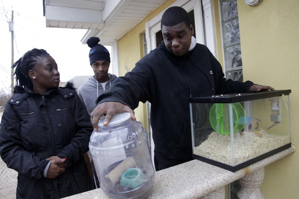 In this Nov. 1, 2012, photo, Gregory Labidou, right, tries to figure out what to do with his pet gerbils and tarantula after he was forced to evacuate his home because of damage from Superstorm Sandy in the Midland Beach section of Staten Island, New York. His aunt, Irmine Celestine, left, agreed to take the gerbils, but not the tarantula, until Labidou could find a more permanent place to stay. Superstorm Sandy drove New York and New Jersey residents from their homes, destroyed belongings and forced them to find shelter for themselves _ and for their pets, said owners, who recounted tales of a dog swimming through flooded streets and extra food left behind for a tarantula no one was willing to take in. (AP Photo/Seth Wenig)