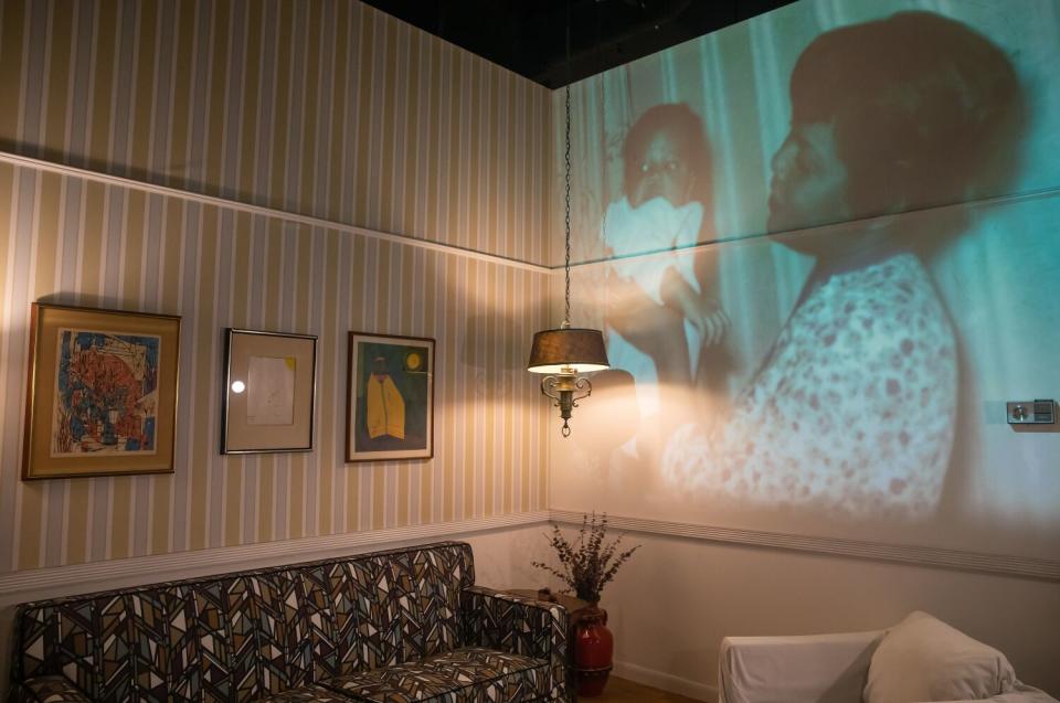 Images are projected on the wall of a living room.