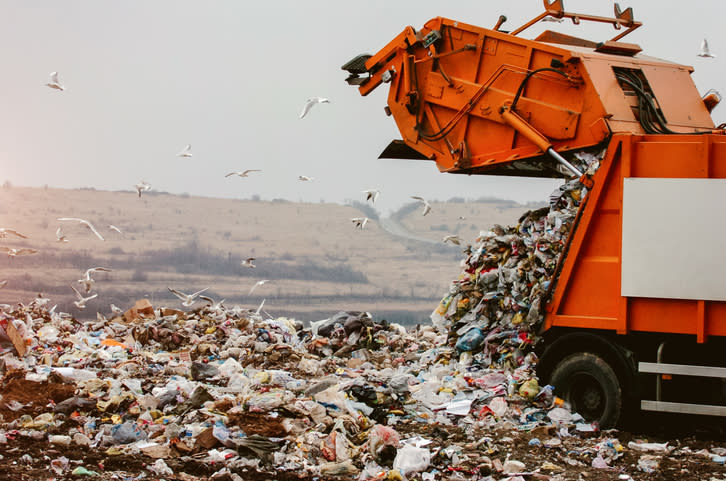 A garbage truck unloading at a landfill.