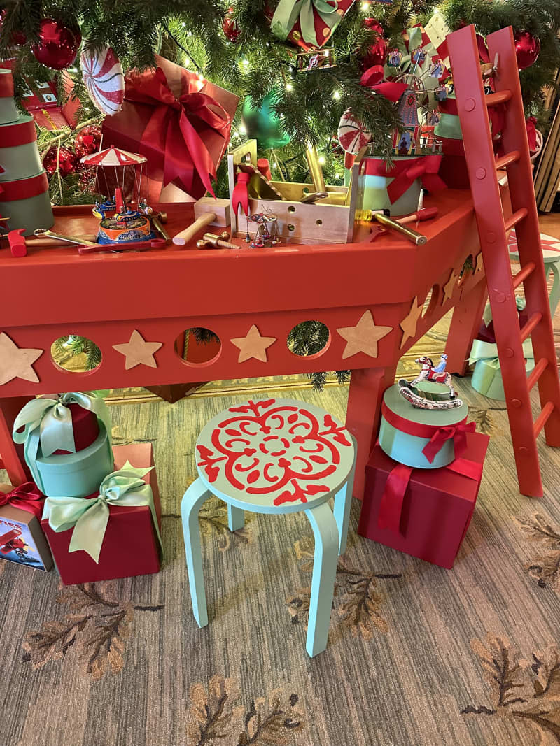 teal and red stencil design stool in front of red table with ladder