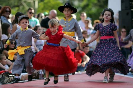 Descendants of American Southerners wearing Confederate-era dresses and uniforms dance during a party to celebrate the 150th anniversary of the end of the American Civil War in Santa Barbara D'Oeste, Brazil, April 26, 2015. REUTERS/Paulo Whitaker