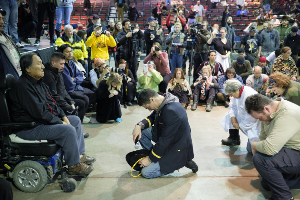 Wesley Clark Jr., middle, and other veterans kneel in front of Leonard Crow Dog during the&nbsp;forgiveness ceremony.