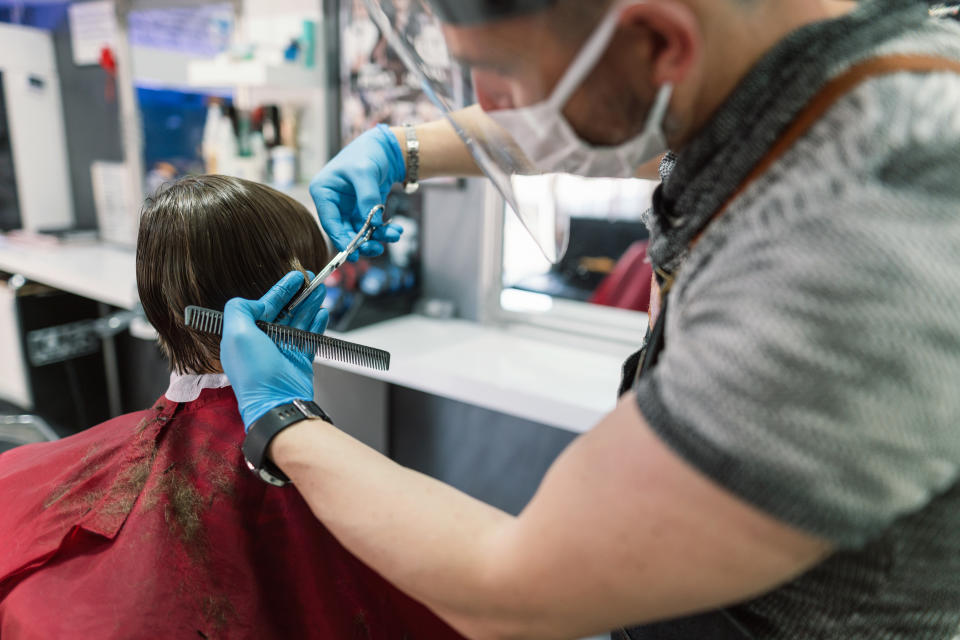 Professional barber cutting little boy’s hair during Coranvirus lockdown