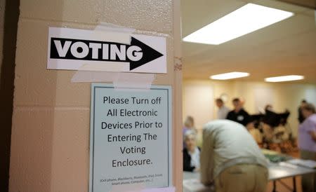 A sign points the way toward the voting booths as voting commences in North Carolina's U.S. presidential primary election at Sharon Presbyterian Church in Charlotte, North Carolina, U.S. on March 15, 2016. REUTERS/Chris Keane/File Photo