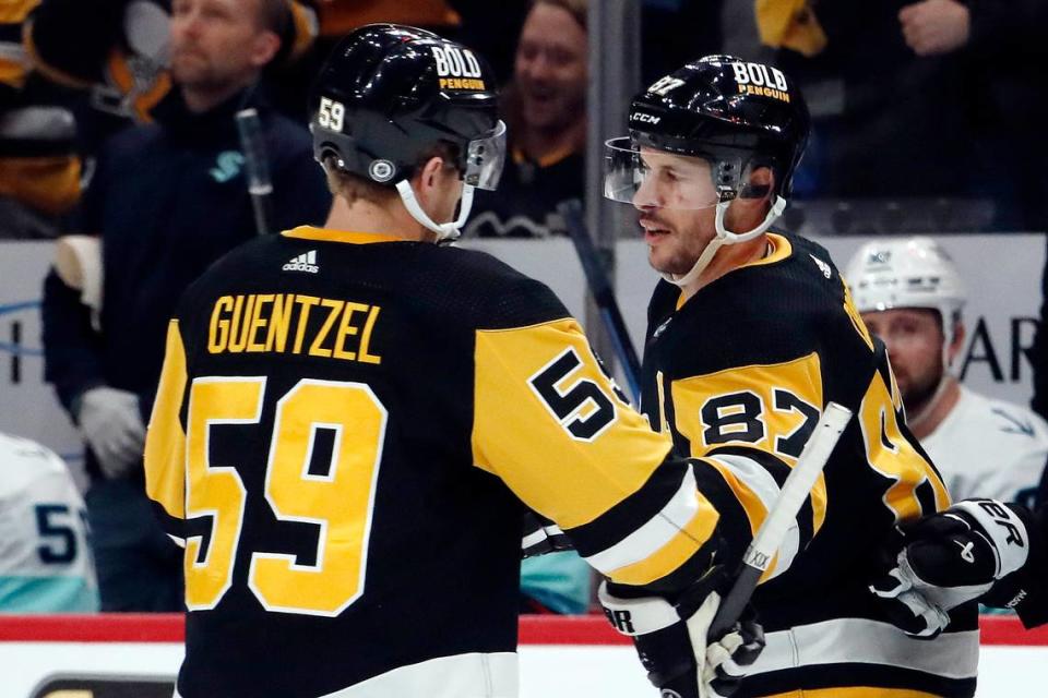 Jan 15, 2024; Pittsburgh, Pennsylvania, USA; Pittsburgh Penguins left wing Jake Guentzel (59) congratulates center Sidney Crosby (87) after Crosby scored an empty net goal to record his second goal of the game against the <a class="link " href="https://sports.yahoo.com/nhl/teams/seattle/" data-i13n="sec:content-canvas;subsec:anchor_text;elm:context_link" data-ylk="slk:Seattle Kraken;sec:content-canvas;subsec:anchor_text;elm:context_link;itc:0">Seattle Kraken</a> during the third period at PPG Paints Arena. Mandatory Credit: Charles LeClaire-USA TODAY Sports Charles LeClaire/Charles LeClaire-USA TODAY Sports