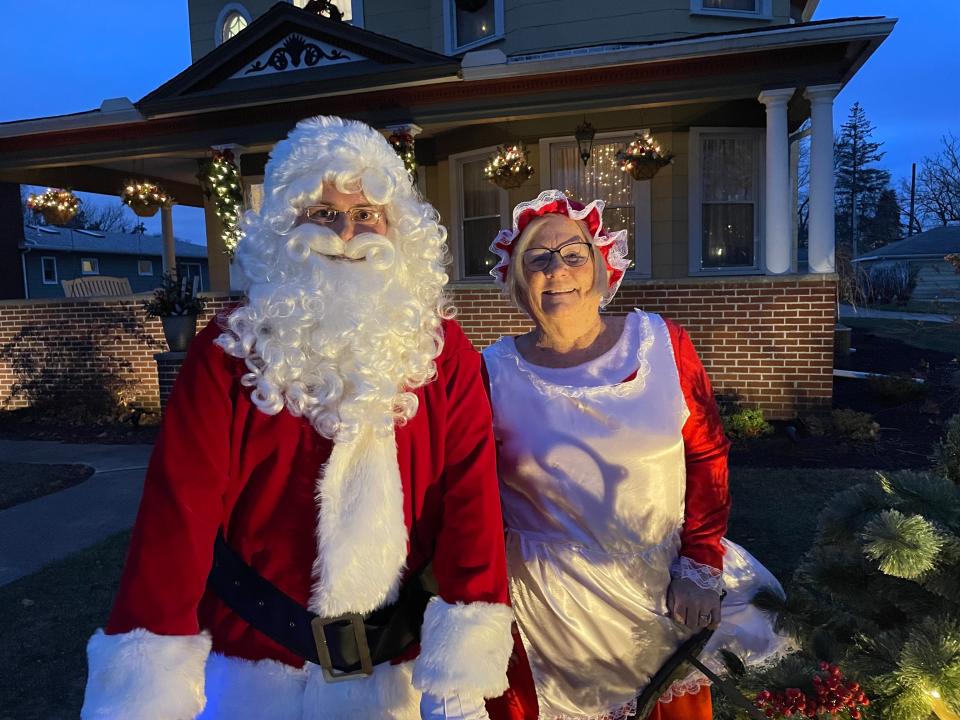 Santa and Mrs. Claus (Sean Rizor and Karen Timbrooks) pause in front of the Rizors' home. The Clauses and the Grinch will meet Woodville children and their families starting at 1 p.m. Saturday at the shelter house.