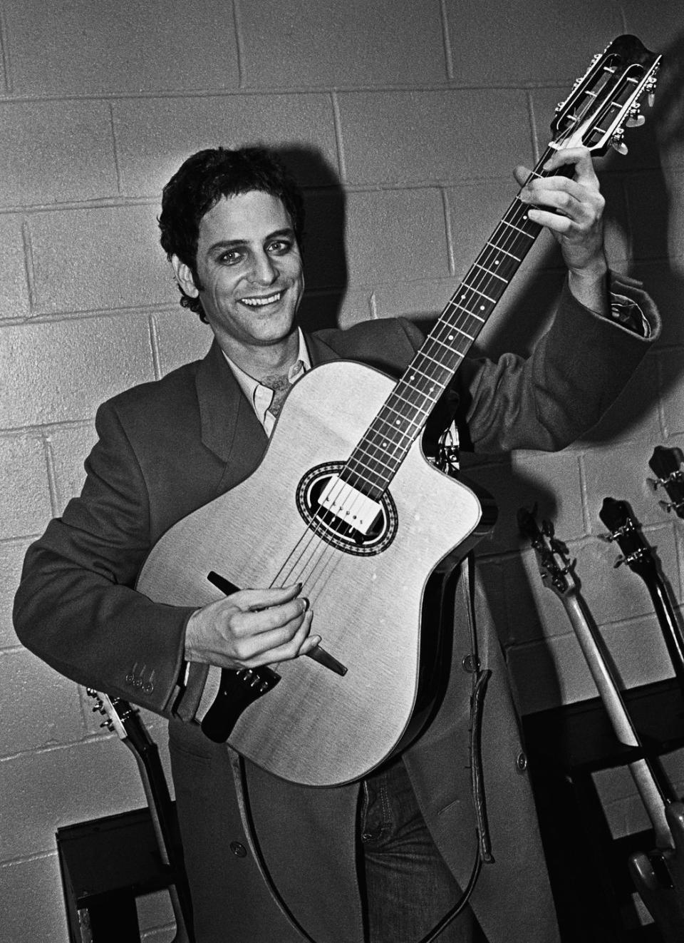 <p>Prior to a 1979 concert, Fleetwood Mac guitarist Lindsey Buckingham poses with one of his many guitars backstage. </p>