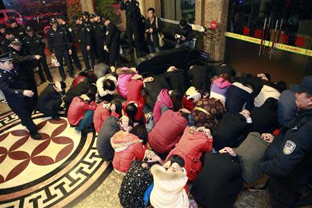 Police conduct a head count of suspects who were detained during a police raid, as part of plans to crackdown on prostitution, at a hotel in Dongguan, Guangdong province, February 9, 2014. REUTERS/Stringer