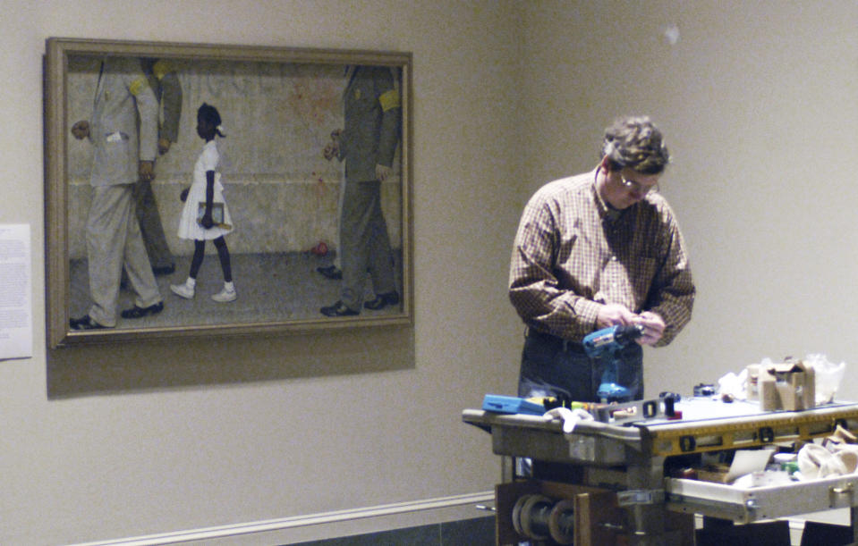 FILE _ A man works at The Norman Rockwell Museum in Stockbridge, Mass., near the painting "The Problem We All Live With," depicting Ruby Bridges desegregating a public school in 1960, in a file photo from Tuesday, May 25, 2004. Bridges has authored a picture book to explain that long-ago experience to the youngest readers. (AP Photo/Nancy Palmieri)