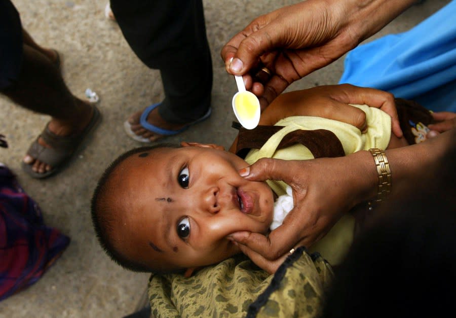 A UNICEF volunteer administers vitamin A syrup to a boy from Nicobar Island at a tsunami relief camp in Port Blair, in India’s southeastern Andaman and Nicobar Islands archipelago, Wednesday, Jan. 5, 2005. The tsunami that smashed Asian and African coastlines on Dec. 26, 2004, has severely damaged parts of the archipelago, with some islands breaking up, land masses tilting and underwater coral reefs emerging above the sea. Indira Point, the farthest tip of the Indian territory, may have just completely disappeared, say army surveyors and survivors. The death toll in India is 9,675. (AP Photo/Manish Swarup)