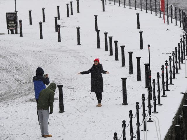 People take photos in the snow in York (John Giles/PA)