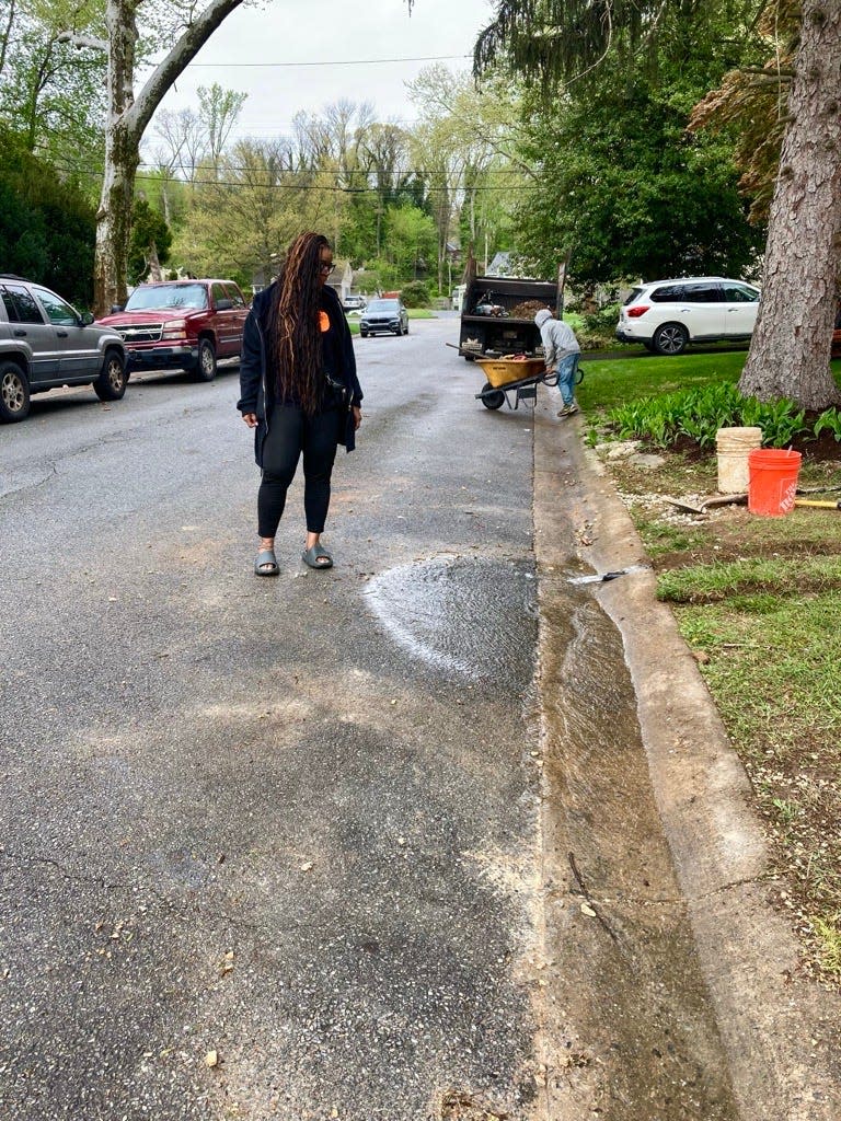 Homeowner Raikka Brent stands next to the curb where an estimated 40,000 gallons of water gets pumped out of her house every day. Water utilities deny being responsible for the water that regularly floods homes and yards in this Edgemoor Terrace neighborhood. April 17, 2024