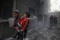 <p>A man holds a child after an airstrike in the besieged town of Douma in eastern Ghouta in Damascus, Syria, Feb. 7, 2018. (Photo: Bassam Khabieh/Reuters) </p>