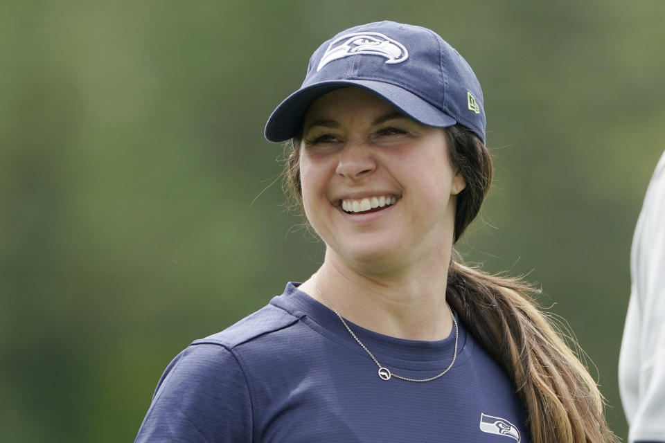 Amanda Ruller, who is currently working as an assistant running backs coach for the NFL football Seattle Seahawks through the league's Bill Walsh Diversity Fellowship program, stands on the field during NFL football practice on June 8, 2022, in Renton, Wash. Ruller's job is scheduled to run through the Seahawks' second preseason game in August. (AP Photo/Ted S. Warren)