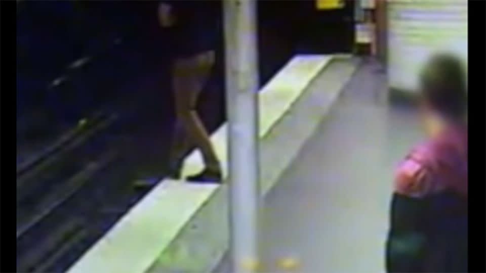 A drunk man can be seen stepping over the platform as a bystander looks on. Photo: francetv