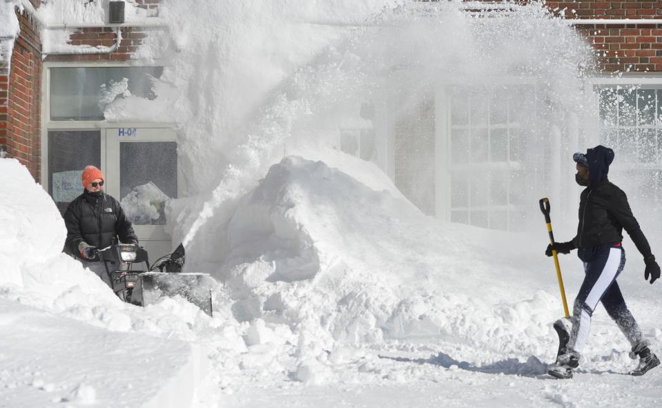 Jeff Banker uses a snowblower to remove snow at the Provincetown International Baccalaureate Schools building Sunday. Camille Williams, right, was helping to dig out.