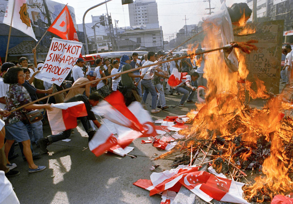 FILE PHOTO: Protesters burn Singaporean flags during a rally, Saturday, March 25, 1995 near the Presidential palace in Manila to protest the execution in Singapore of Filipino maid, Flor Contemplacion. (AP Photo/Pat Roque)