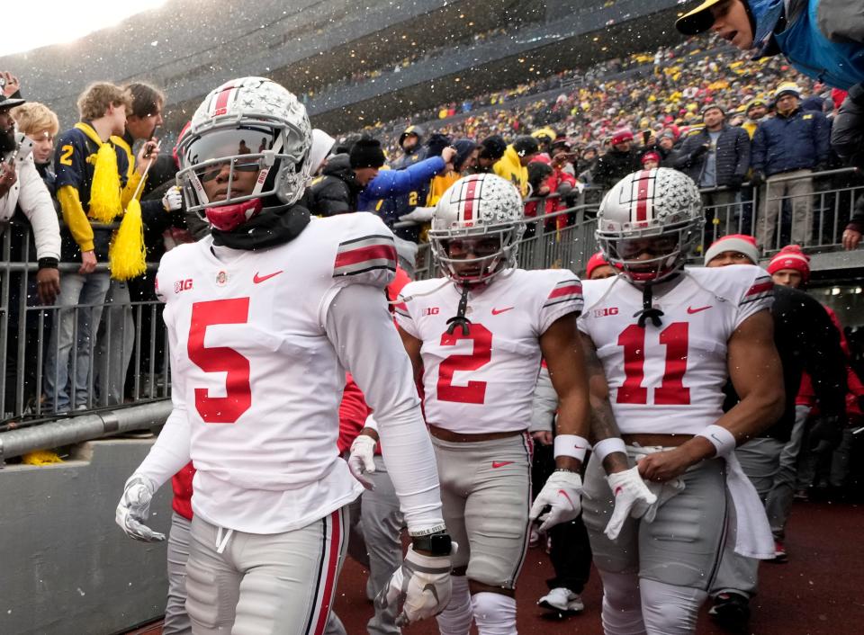 Ohio State Buckeyes wide receivers Garrett Wilson (5), Chris Olave (2) and Jaxon Smith-Njigba (11) take the the field for the NCAA football game against the Michigan Wolverines at Michigan Stadium in Ann Arbor on Sunday, Nov. 28, 2021. 