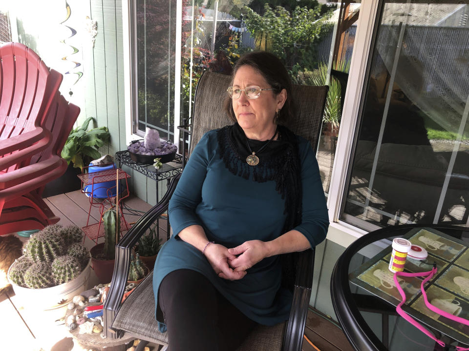 Barbara Trout, who has an asthma disorder, keeps her asthma medicine and a neck alarm next to her on the table, at right, at her home in Keizer, Ore., Wednesday, Oct. 14, 2020. (AP Photo/Andrew Selsky)