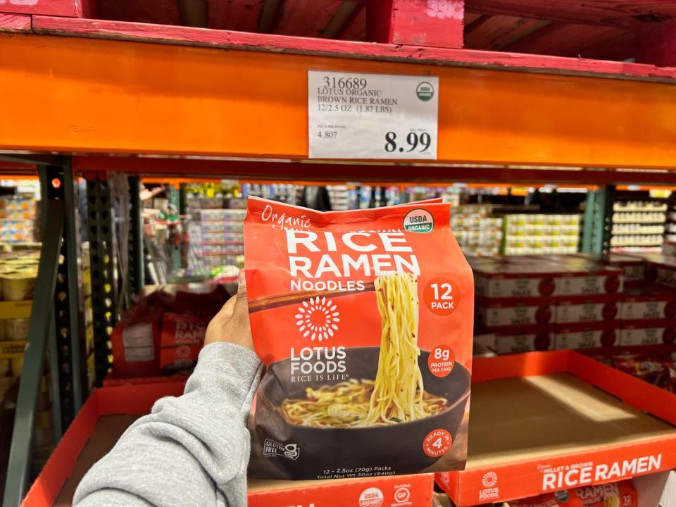 hand holding up a pack of lotus food s rice ramen at costco