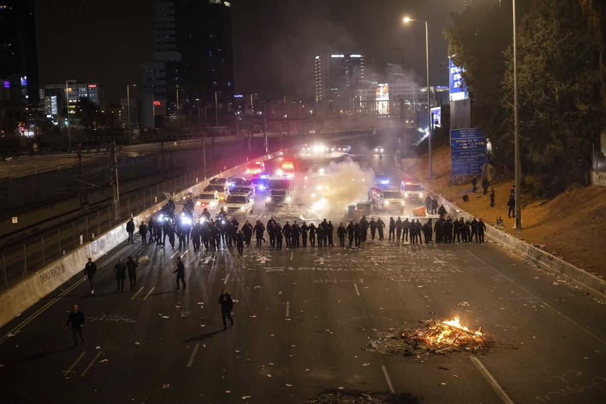 Israeli police disperse demonstrators blocking a highway during a protest against plans by Prime Minister Benjamin Netanyahu's government to overhaul the judicial system in Tel Aviv, Israel, Monday, March 27, 2023. Tens of thousands of Israelis have poured into the streets across the country in a spontaneous outburst of anger after Prime Minister Benjamin Netanyahu abruptly fired his defense minister for challenging the Israeli leader's judicial overhaul plan. (AP Photo/Oren Ziv)