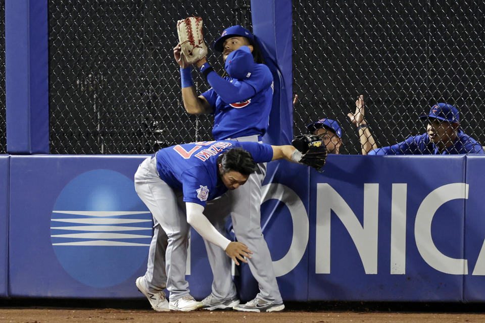 Chicago Cubs center fielder Michael Hermosillo makes a catch after colliding with Seiya Suzuki on a ball hit by New York Mets' Eduardo Escobar during the ninth inning of a baseball game on Wednesday, Sept. 14, 2022, in New York. The Cubs won 6-3. (AP Photo/Adam Hunger)