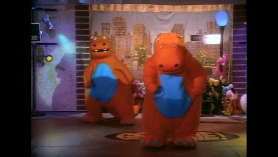 photo of two orange hippo costumes standing on a fake set of dinosaurs tv show episode georgie must die