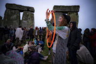 People inside the stone circle during Summer Solstice at Stonehenge, where some people jumped over the fence to enter the stone-circle to watch the sun rise at dawn of the longest day of the year in the UK, in Amesbury, England, Monday June 21, 2021. The prehistoric monument of ancient stones have been officially closed for the celebrations due to the coronavirus lockdown, but groups of people ignored the lockdown to mark the Solstice, watched by low key security. (Ben Birchall/PA via AP)