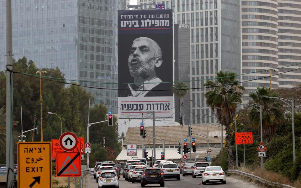Hebrew written on a portrait of Sinwar on a billboard in Tel Aviv reads: 'Think well of who benefits from our division - unity now'