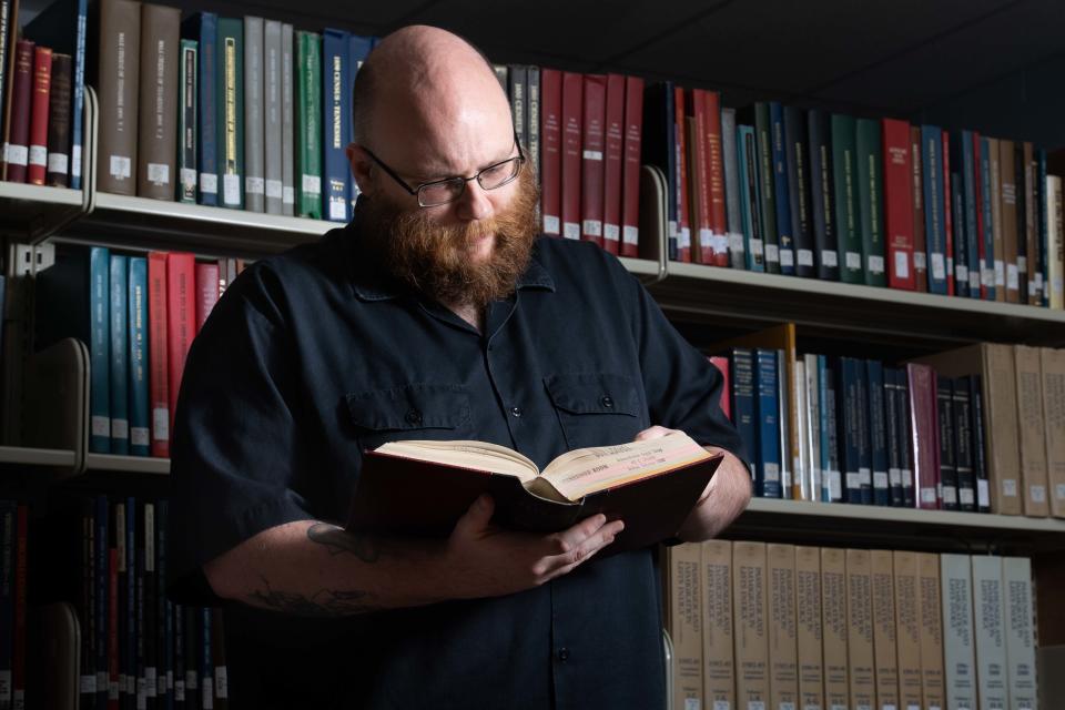 Brendan Rowe looks through the 1970 Jackson-Madison County record book while inside The Tennessee Room at Jackson-Madison County Library on Wednesday, July 25, 2023.