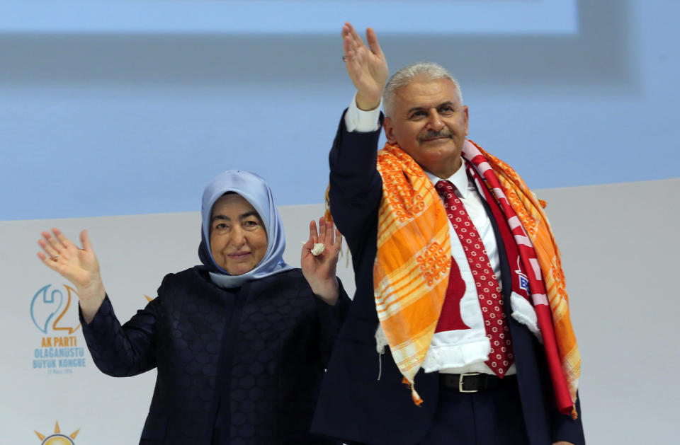 <p>Binali Yildirim, Turkey’s current Transportation Minister and founding member of the AKP, Turkey's governing party, and his wife Semiha Yildirim salute supporters during party congress in Ankara, Turkey, May 22, 2016. Turkey’s ruling party held a special convention on Sunday to confirm Binali Yildirim, a longtime ally of President Recep Tayyip Erdogan as its new chairman and next prime minister, a move that is likely to consolidate the Turkish leader’s hold on power. (Riza Ozel/AP)) </p>