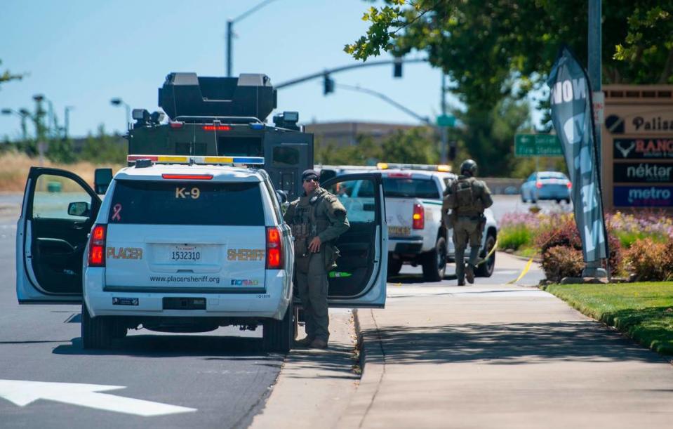 Placer County sheriff’s deputies wait on Sunday, July 9, 2023, at the staging area for the manhunt for escaped Mahany Park murder suspect Eric James Abril, who escaped early in the morning from a Roseville hospital, at Palisades Plaza in Roseville.