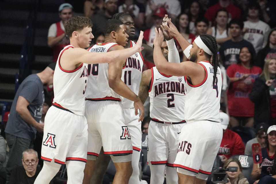 Arizona players, left to right, Pelle Larsson, Keshad Johnson, Oumar Ballo, Caleb Love and Kylan Boswell celebrate during the first half of an NCAA college basketball game Thursday, Feb. 1, 2024, in Tucson, Ariz. Arizona won 91-65. (AP Photo/Darryl Webb)