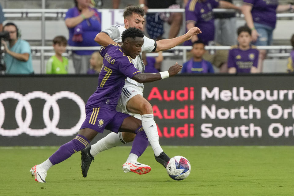 Orlando City's Ivan Angulo, left, moves the ball toward the goal as Toronto FC's Kobe Franklin defends during the first half of an MLS soccer match Tuesday, July 4, 2023, in Orlando, Fla. (AP Photo/John Raoux)