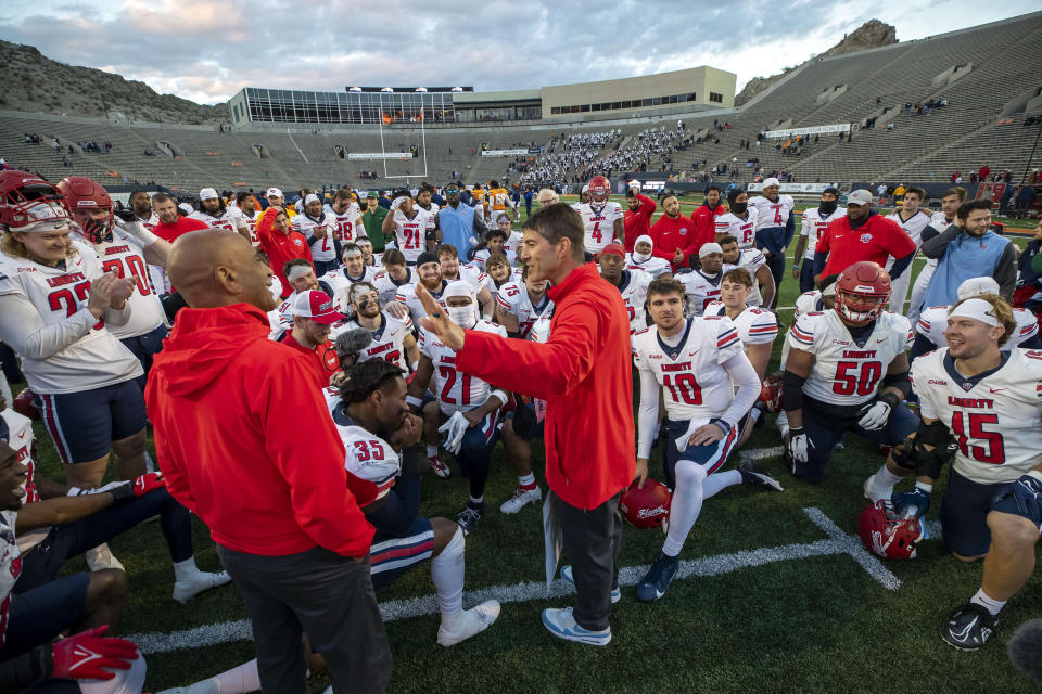 Liberty coach Jamey Chadwell, center, congratulates his players after beating UTEP 42-28 in an NCAA college football game on Saturday, Nov. 25, 2023, in El Paso, Texas. Liberty became the first Division I team from Virginia to win 12 games in a season. (AP Photo/Andres Leighton)