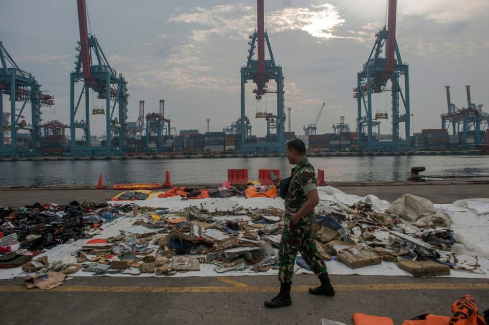 An Indonesian soldier at Tanjung Priok Port in Jakarta walks past debris retrieved from the waters where Lion Air flight JT 610 is believed to have crashed in the Java Sea.