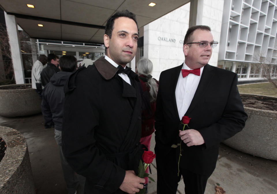 Nasir Khawaja, left, and Mark Sarver stand outside in line to apply for a marriage license at the Oakland County Clerks office in Pontiac, Mich., Saturday, March 22, 2014. A federal judge has struck down Michigan's ban on gay marriage Friday the latest in a series of decisions overturning similar laws across the U.S. Some counties plan to issue marriage licenses to same-sex couples Saturday, less than 24 hours after a judge overturned Michigan's ban on gay marriage. (AP Photo/Paul Sancya)