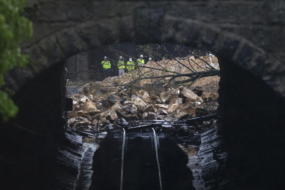 Emergency officials are seen through a CSX railroad tunnel near debris that fell onto tracks in the Charles Village neighborhood of Baltimore, Wednesday, April 30, 2014, as heavy rain moves through the region. Road closures have been reported due to flooding, downed trees and electrical lines elsewhere in the Mid-Atlantic. The National Weather Service issued flash flood warnings through Wednesday afternoon in Washington, northern Virginia and central Maryland. (AP Photo)