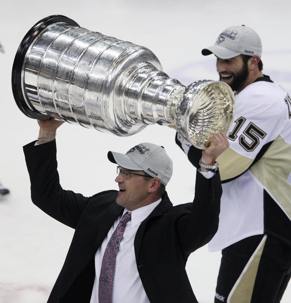 FILE - In this June 12, 2009, file photo, Pittsburgh Penguins head coach Dan Bylsma raises the Stanley Cup after the Penguins defeated the Detroit Red Wings to win Game 7 of the NHL hockey Stanley Cup finals in Detroit. It is Game 4 Friday, Sept. 25, 2020, and right back for Game 5 Saturday night for the Tampa Bay Lightning and Dallas Stars in just the second Stanley Cup Final with a back-to-back since the mid-1950s. It was Games 1 and 2 for then-coach Bylsma’s Penguins and the Red Wings. (AP Photo/Carlos Osorio, File)