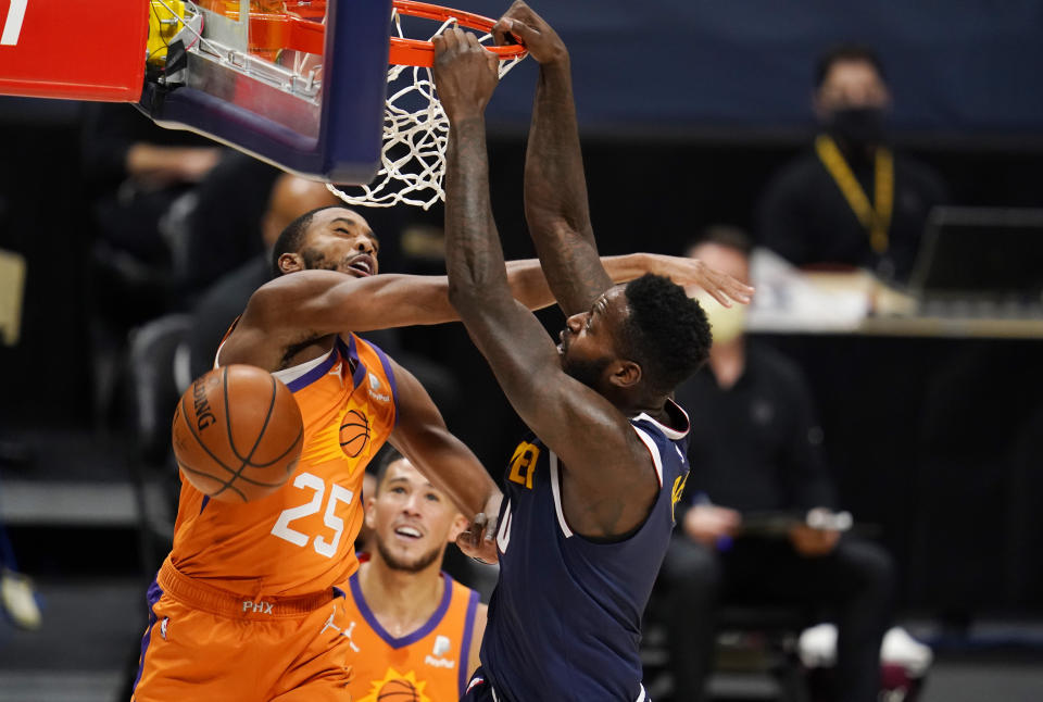Phoenix Suns forward Mikal Bridges, left, fouls Denver Nuggets forward JaMychal Green on a dunk during the second half of an NBA basketball game Friday, Jan. 1, 2021, in Denver. (AP Photo/David Zalubowski)