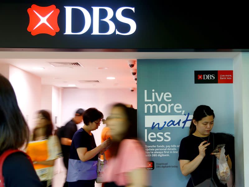 FILE PHOTO: FILE PHOTO: People walk past a DBS branch in Singapore