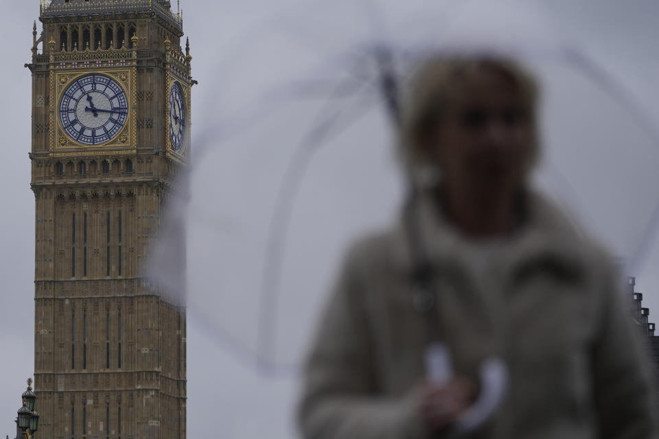 A woman holds an umbrella as she walks on Westminster Bridge over the River Thames with the clock face of Queen Elizabeth Tower in the background in London, Friday, May 3, 2024. Britain's governing Conservative Party is suffering heavy losses as local election results pour in Friday, piling pressure on Prime Minister Rishi Sunak ahead of a U.K. general election in which the main opposition Labour Party appears increasingly likely to return to power after 14 years. The Queen Elizabeth Tower holds the bell known as Big Ben. (AP Photo/Kin Cheung)