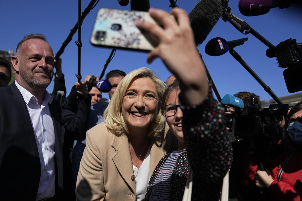 French far-right leader and presidential candidate Marine Le Pen poses for a selfie as she campaigns Friday, April 22, 2022 in Etaples, northern France. Centrist candidate and French President Emmanuel Macron is facing off against far-right challenger Marine Le Pen in France's April 24 presidential runoff. (AP Photo/Michel Euler)