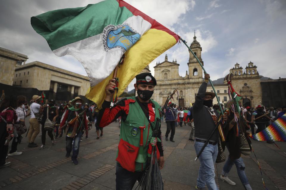 Indigenous protesters march against the government in Bogota, Colombia, Monday, Oct. 19, 2020. The leaders of the indigenous communities say they are mobilizing to reject massacres, assassinations of social leaders, criminalization of social protest, to defend their territory, democracy and peace, and plan to stay in the capital for a nationwide protest and strike on Oct. 21. (AP Photo/Fernando Vergara)