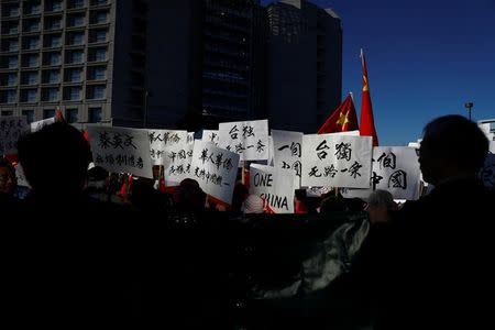 Demonstrators hold signs in protest against Taiwan President Tsai Ing-wen during a stop-over after her visit to Latin America in Burlingame, California, U.S., January 14, 2017. REUTERS/Stephen Lam