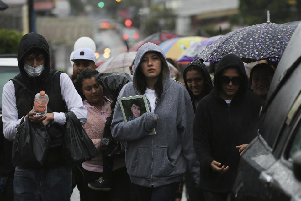 In this Feb. 5, 2020 photo, family and friends attend a funeral procession for a victim of a shooting at a video-game arcade in Uruapan, Mexico. Uruapan, a city of about 340,000 people, is in Mexico's avocado belt, where violence has reached shocking proportions. In Uruapan, cartels are battling for territory and reports of killings are common, such as the gun massacre last week of three young boys, a teenager and five others at an arcade in what had been a relatively quiet neighborhood. (AP Photo/Marco Ugarte)