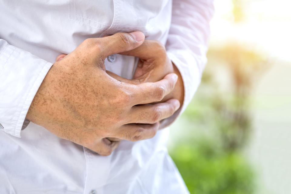 A person hurts a painful stomach and holds a painful place with his hands, Gastritis, Stomach pain, Reflux acids.