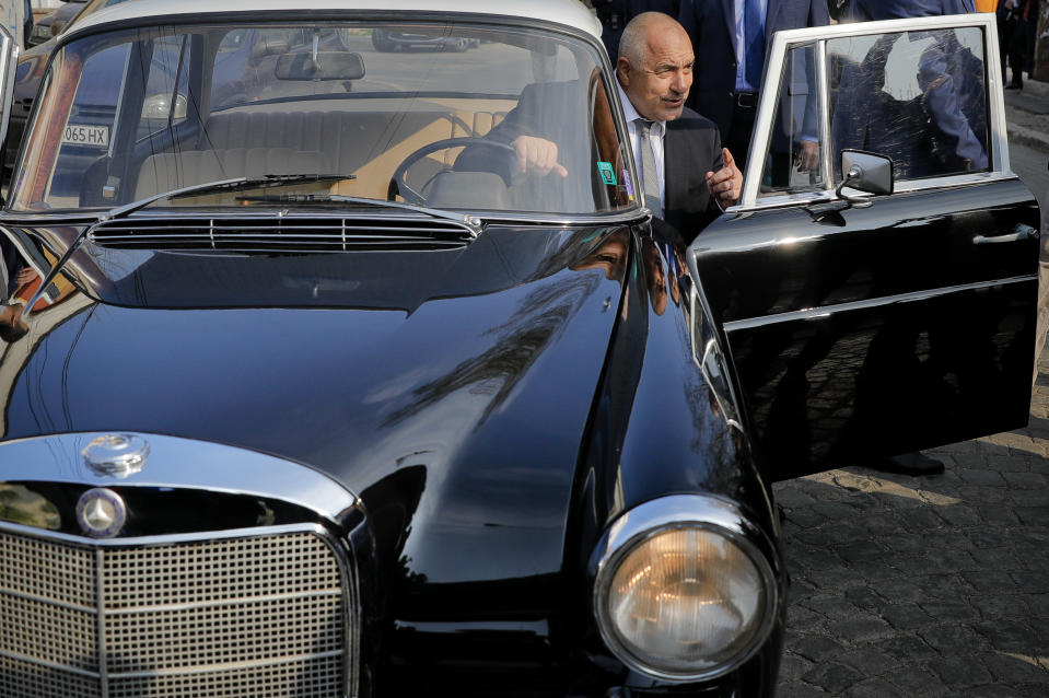 Bulgarian ex-Premier Boiko Borisov, leader of the center-right GERB party, gets into the driver's seat of a vintage Mercedes as he leaves a voting station, in Sofia, Bulgaria, Sunday, March 26, 2017. Bulgarians are heading to the polls for the third time in four years in a snap vote that could tilt the European Union's poorest member country closer to Russia as surveys put the center-right GERB party neck-and-neck with the Socialist Party. (AP Photo/Vadim Ghirda)